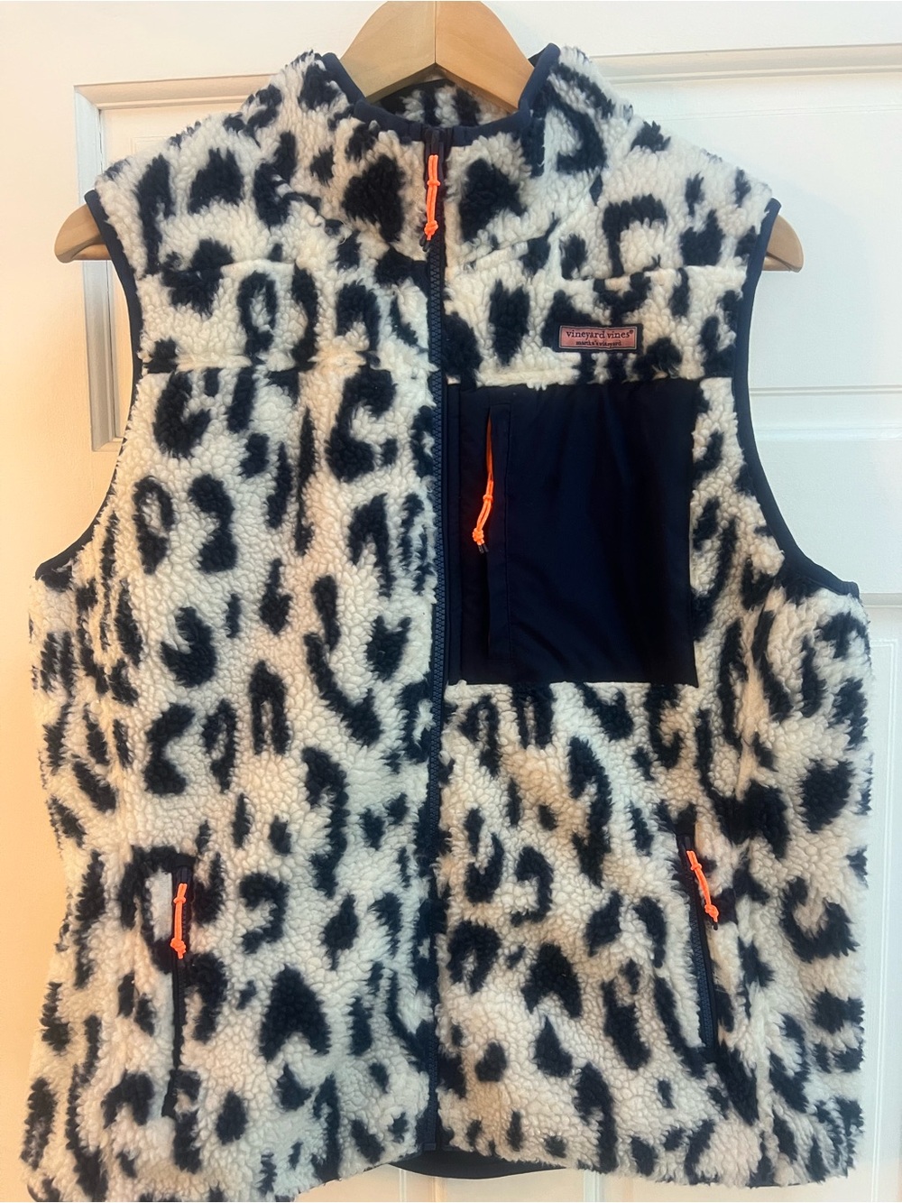 Navy leopard fleece vest with orange accents.